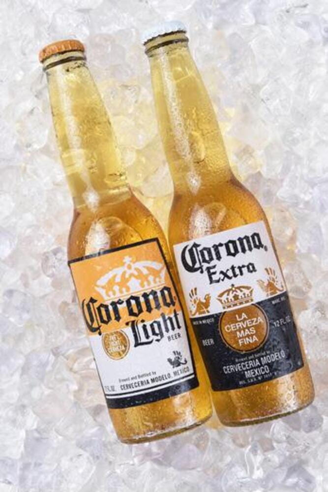 Two bottles of Corona Extra and Light Beer on ice. Corona is the most popular imported beer in the USA. Two bottles of Corona Extra and Light Beer on ice. Corona is the most popular imported beer in the USA.