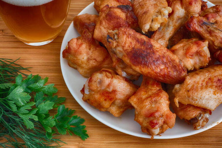 Baked chicken wings with beer and dill with parsley. Close up. Baked chicken wings with beer and dill with parsley. Close up.
