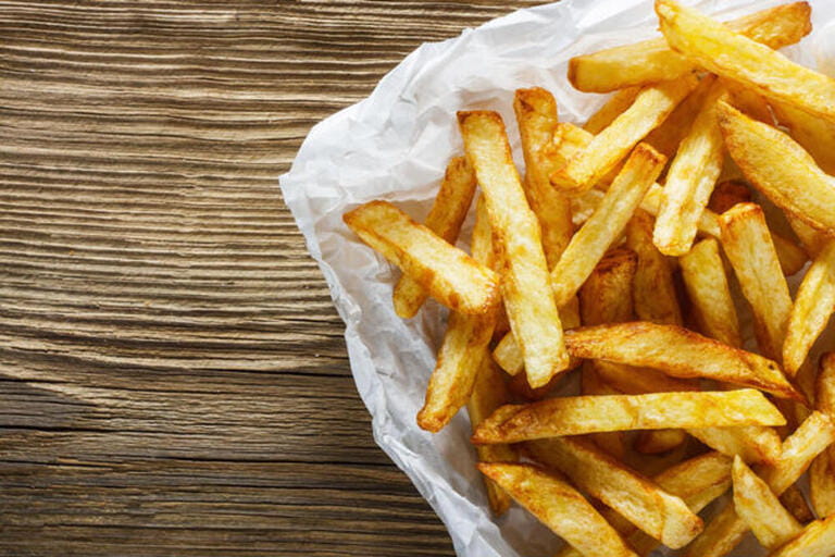 French fries on wooden table French fries on wooden table