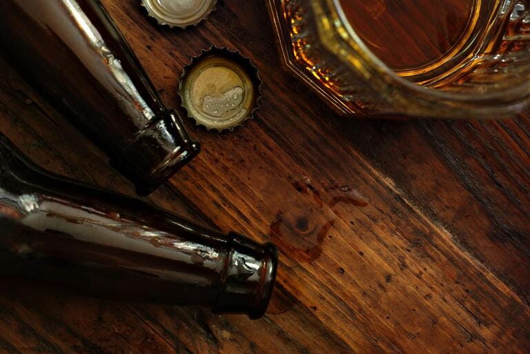Top view of near empty beer glass with bottle caps and bottles on rustic wooden background. Top view of near empty beer glass with bottle caps and bottles on rustic wooden background.
