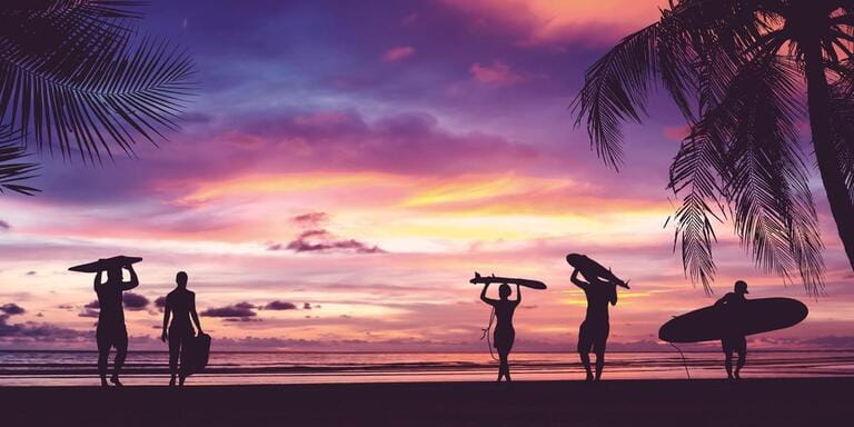 Silhouette of surfers carrying their surfboards on sunset beach. Silhouette of surfers carrying their surfboards on sunset beach.