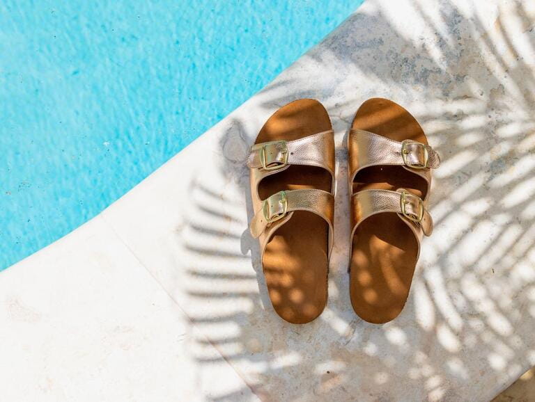 Beach shoes in the shadow of a palm tree Beach shoes in the shadow of a palm tree