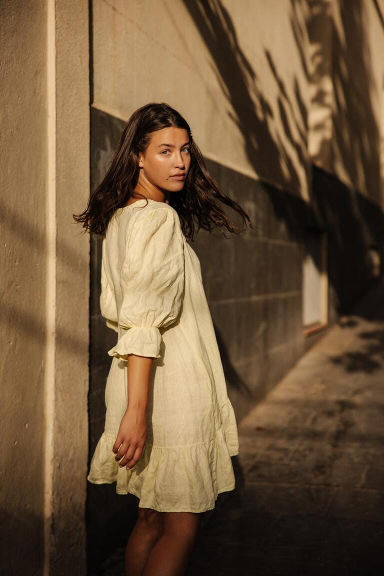 Stylish young caucasian girl looking at camera spending free time outdoors. In summer, brunette wears loose dress. Stylish young caucasian girl looking at camera spending free time outdoors. In summer, brunette wears loose dress.