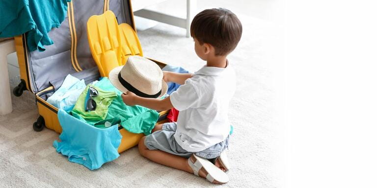 Little boy packing suitcase at home. Banner for design Little boy packing suitcase at home. Banner for design