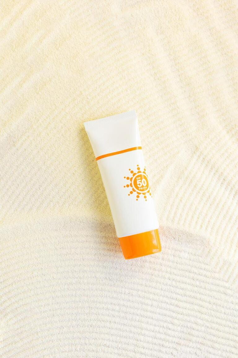 white cosmetic tube with sunscreen cream on sand textured background. Cosmetic products with spf. UV protection concept. white cosmetic tube with sunscreen cream on sand textured background. Cosmetic products with spf. UV protection concept.