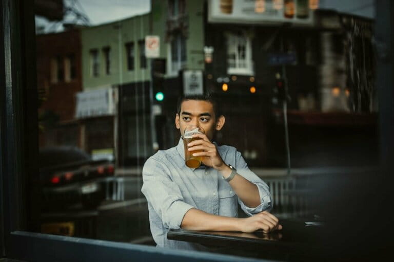 Young man having beer while looking out of window in cafe Young man having beer while looking out of window in cafe