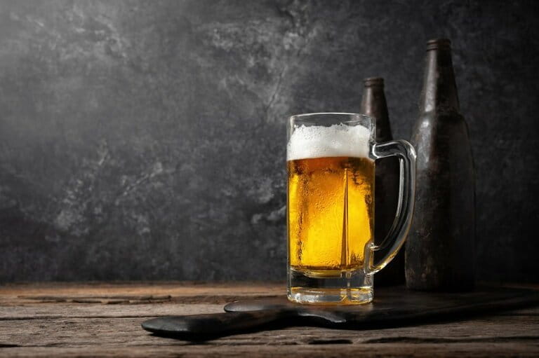 Glass of beer on a wooden table with two old bottles. Glass of beer on a wooden table with two old bottles.