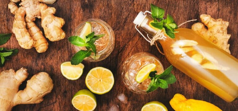 Ginger Ale Cocktail with Beer, Lemon, Lime and Mint in glaass on wooden table Ginger Ale Cocktail with Beer, Lemon, Lime and Mint in glaass on wooden table