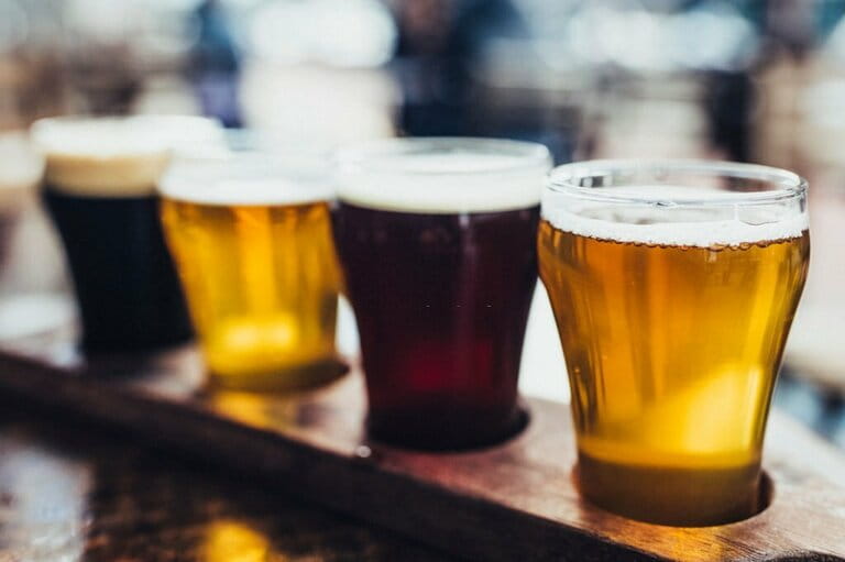 Close-up shot of four kinds of beer on a microbrewery wooden palette, also known as a beer flight. Close-up shot of four kinds of beer on a microbrewery wooden palette, also known as a beer flight.