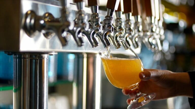 A glass of beer being poured from a tap A glass of beer being poured from a tap