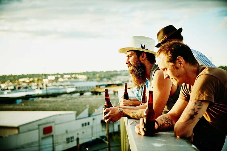 Group of friends leaning on railing on rooftop Group of friends leaning on railing on rooftop